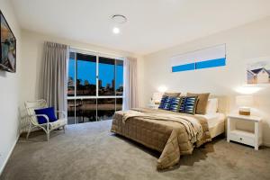 a bedroom with a bed and a large window at Sandy Cove in Gold Coast +21 photos