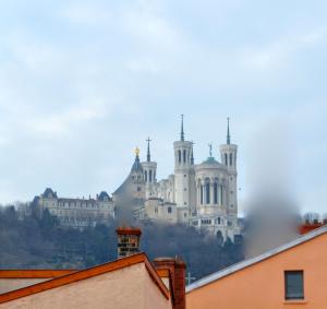 un castillo en la cima de una colina con edificios en Le Secret des Templiers en Lyon