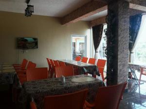 a dining room with a table and orange chairs at RSG Microhotel in General Santos
