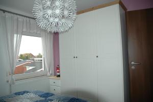 a bedroom with a bed and a chandelier at Huus Veertein in Neuharlingersiel