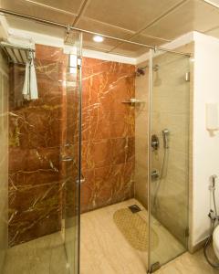 a shower stall with a glass door in a bathroom at Park Ornate Hotel in Pune