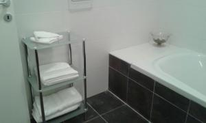 a bathroom with a sink and a shelf with towels at Sliema sea front balcony in Sliema