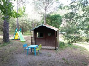 a small cabin with a table and chairs and a slide at Les Gîtes Les Mayombes in Roquebrune-sur-Argens
