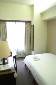 Postel nebo postele na pokoji v ubytování Ryukyu Sun Royal Hotel