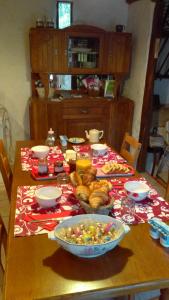 einen Tisch mit einem Tischtuch mit Essen drauf in der Unterkunft Les 3 roses in Villeneuve-sur-Yonne