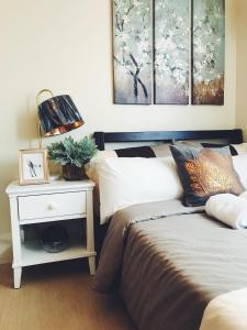 a bedroom with a bed and a table with a night stand at Davao Boutique Condos - Avida in Davao City