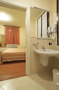 a bathroom with a sink and a bed at Hotel Bellavista in Valmadrera