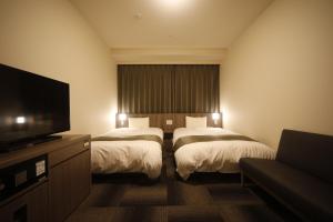 Ein Bett oder Betten in einem Zimmer der Unterkunft Dormy Inn Korakuen