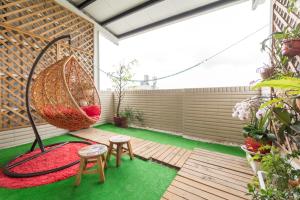 a patio with a hammock and two stools and a swing at E-Phone Homestay in Ji'an