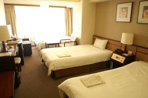 Postel nebo postele na pokoji v ubytování Ryukyu Sun Royal Hotel