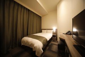 Ein Bett oder Betten in einem Zimmer der Unterkunft Dormy Inn Korakuen