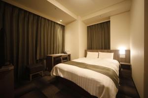 Ein Bett oder Betten in einem Zimmer der Unterkunft Dormy Inn Korakuen