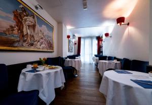 a dining room with tables and chairs and a painting on the wall at Antico Hotel Vicenza in Vicenza