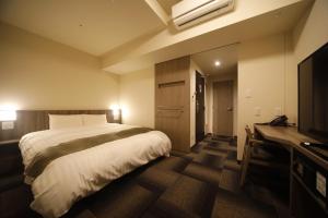 Ein Bett oder Betten in einem Zimmer der Unterkunft Dormy Inn Korakuen