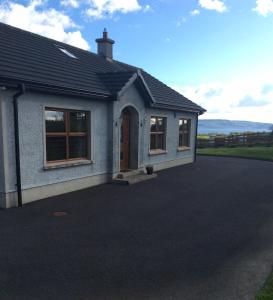 a house with a driveway in front of it at Erne View Cottage in Kesh