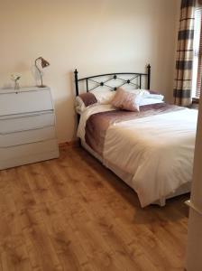 a bedroom with a bed and a wooden floor at Erne View Cottage in Kesh