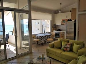 a living room with a green couch and a kitchen at Luxury Sea View in Ofrínion