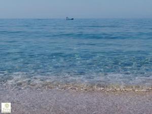 a person in a boat in the ocean at Frini Studios in Plomari