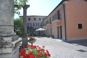 a courtyard with a building and flowers in a pot at Albergo Minuetto in Adria