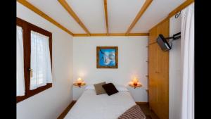 a small bedroom with a bed and two lamps at La Cerca Del Alcornoque in Casas de Belvis