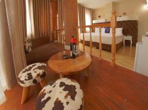 1 dormitorio con 1 cama, mesa y sillas en The Red Bricks Hotel en Shkodër