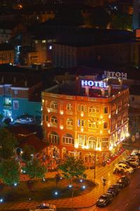 a hotel with a sign on top of it at night at The Red Bricks Hotel in Shkodër
