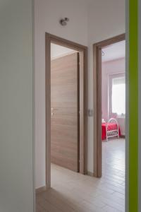 una puerta de madera en una habitación con pasillo en Grossi Apartment, en Rho