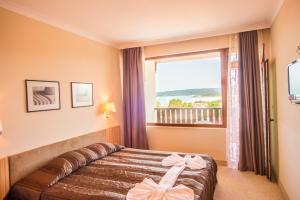 a hotel room with a bed with bows on it at Arkutino Family Resort in Sozopol