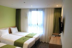 ソウルにあるホテル クレタケソウ インサドンのベッド2台と窓が備わるホテルルームです。