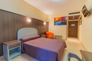 a hotel room with a bed and a chair at Hotel Monreal Jumilla in Jumilla