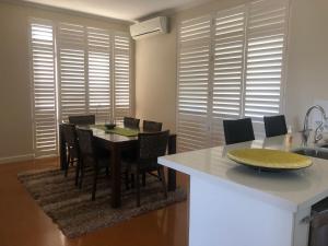a kitchen and dining room with a table and chairs at Allora Apartment Applecross in Perth
