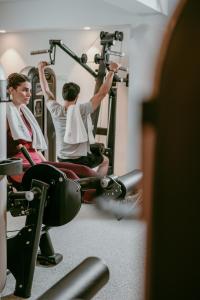 two people sitting in a gym on machines at Lebay Beach Hotel in Larnaca