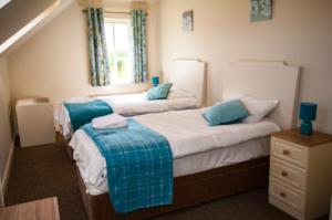 a bedroom with two beds and a window at Erne View Cottages in Lisnaskea