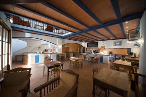 a large room with tables and chairs and a kitchen at Crux Albergue in Adahuesca