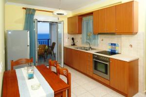 a kitchen with a table and a dining room at Mari-Christi Apartments in Poros