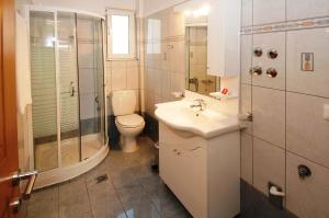 a bathroom with a toilet and a sink and a shower at Mari-Christi Apartments in Poros +34 photos