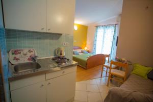 a kitchen with a sink and a living room at Ivan Apartment in Makarska