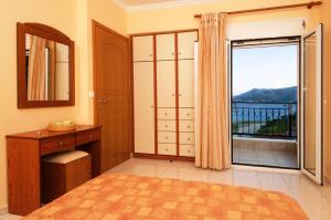 a bedroom with a view of a balcony at Mari-Christi Apartments in Poros