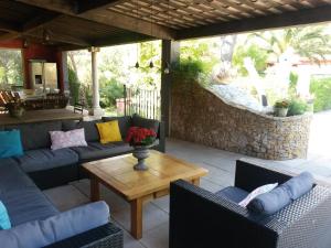 a patio with couches and a table with flowers on it at Les Mayombes in Roquebrune-sur-Argens
