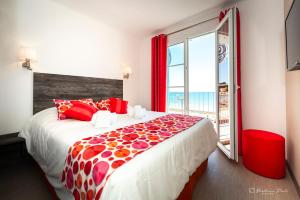 a bedroom with a large bed and a large window at Hôtel George Sand in La Seyne-sur-Mer