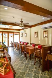 فندق Mhonsa في شيانغ ماي: غرفة طعام مع طاولات وكراسي خشبية