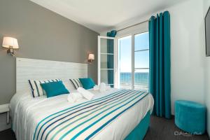 a bedroom with a large bed with a large window at Hôtel George Sand in La Seyne-sur-Mer
