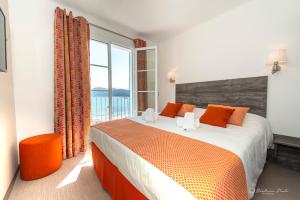 a bedroom with a large bed and a large window at Hôtel George Sand in La Seyne-sur-Mer