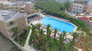 an aerial view of a resort swimming pool with palm trees at Atrion Resort Hotel in Agia Marina Nea Kydonias