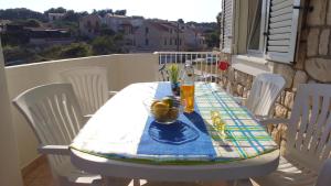 Apartment Karuza Rukavac في فيس: طاولة مع كراسي بيضاء وقطعة قماش من الطاولة الزرقاء والبيضاء