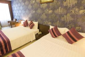 a hotel room with two beds and a wallpaper at Ngoc Linh Luxury Hotel in Vung Tau