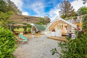 ein winziges Haus mit einer Terrasse und einem Sonnenschirm in der Unterkunft Camping Resort Tina Vrsar in Vrsar