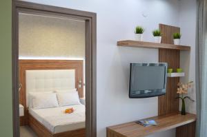 ネア・ポティダイアにあるAqua Luxury Villasのベッドルーム1室(ベッド1台、壁にテレビ付)