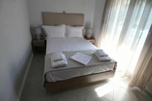 a bedroom with a bed with two towels on it at Pan Mare in Skala Sotiros