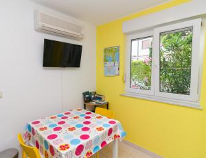 ein Esszimmer mit einem Tisch und einem Fenster in der Unterkunft • Lungomare Beach Apartment Pula • in Pula